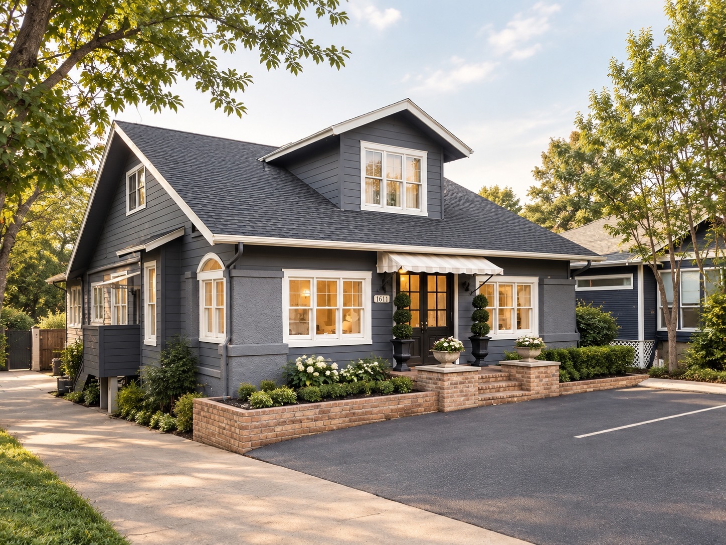 Exterior of the Austin Med Spa building at 1611 in Austin, TX — a slate-grey craftsman house with a striped awning over the entrance and off-street parking